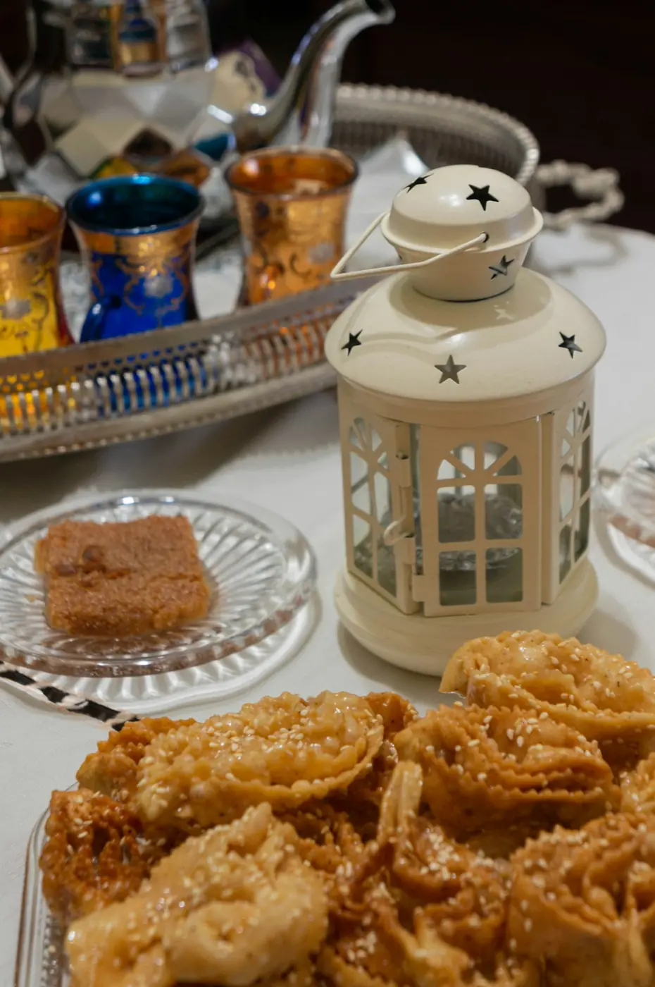 Honey-coated chebakia cookies next to a teapot and a lantern